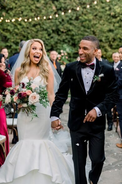 Bride and groom walking hand in hand down the aisle