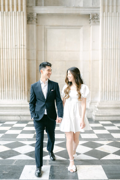 Bride and groom are walking side by side looking at each other smiling. Elopement wedding in Marylebone London