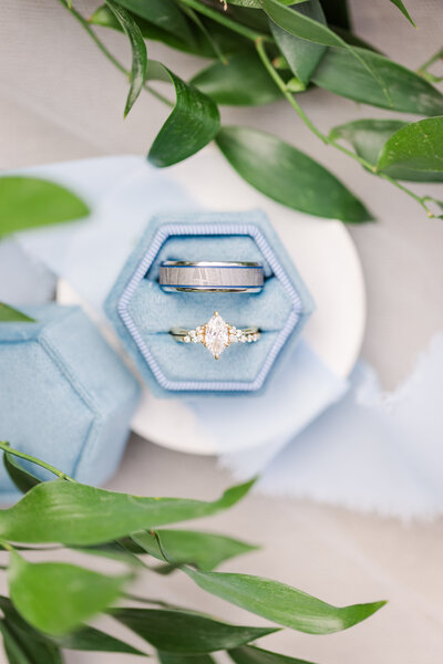 wedding ring with blue ring holder and leaves sounding it