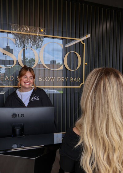 Client checking in at the SoCo Head Spa front desk, ready for a relaxing scalp care experience.