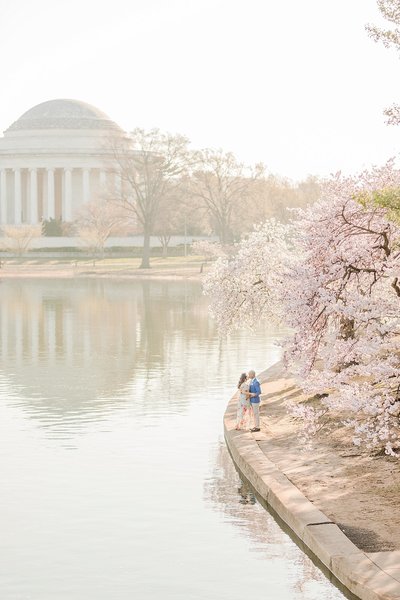 couple kissing by the tidal basin during the cherry blossoms in washington dc by costola photography