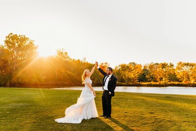 photo of bride and groom  dancing at sunset
