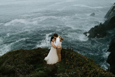 eloping couple standing under fallen tree