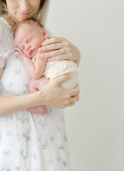 Mother embraces sleeping newborn