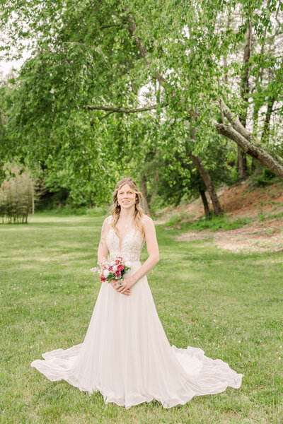 bride holding boutque at waist level looking down towards the ground at Freeman lake in Elizabethtown, KY