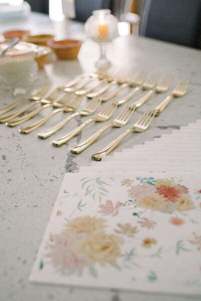 Custom printed napkins featuring floral designs matching the letterpress invitations for a pink and yellow girl’s baby shower.