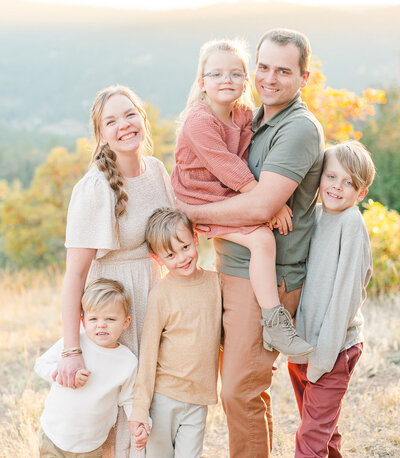 Big family smiles at the camera during their family portrait session in Denver, Colorado.