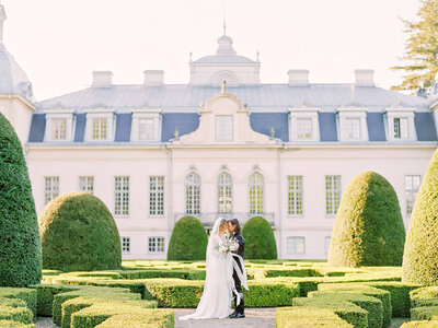 Kronovalls Vinslott bride and groom closely together in the geometric garden
