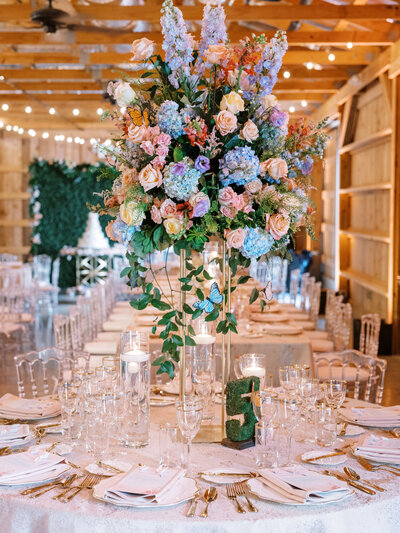 Pastel wedding centerpiece with moss covered table number at Saddle Woods Farm wedding.