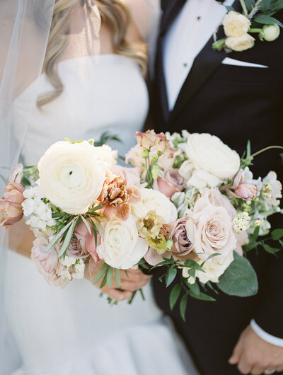 A fall wedding bouquet that has white and mauve flowers