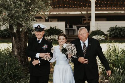 Bride walking down the aisle with two men holding her arms, Berkshire Farm Wedding