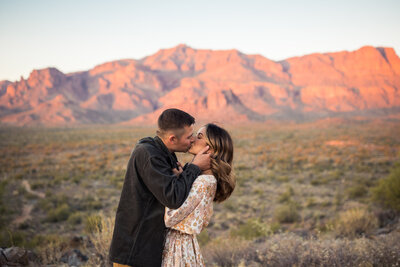 couple kissing in front of the superstition mountains
