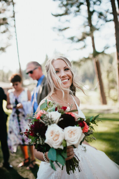 Smiling bride holds wedding bouquet