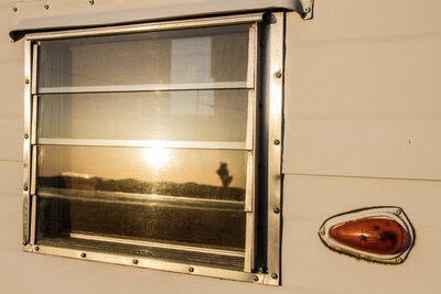 Location Branding photo closeup of airstream trailer window with tail light