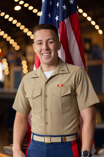 Marine officer senior portrait in Dahlgren Hall with American flag at US Naval Academy in Annapolis, Maryland.