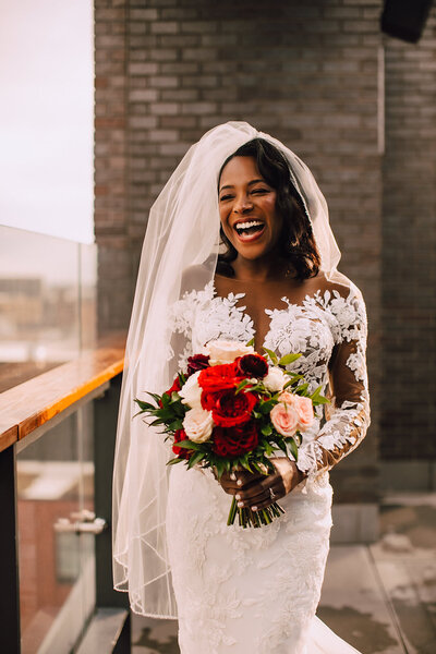Bride laughs on rooftop