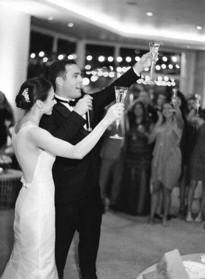 Bride and groom raise their glasses for a toast at their wedding reception