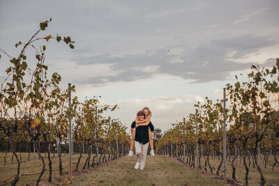 couple piggybacking in australian vineyard