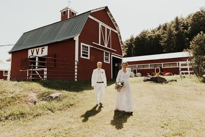 Brides in front of red barn at wedding venue, Berkshire Farm Wedding