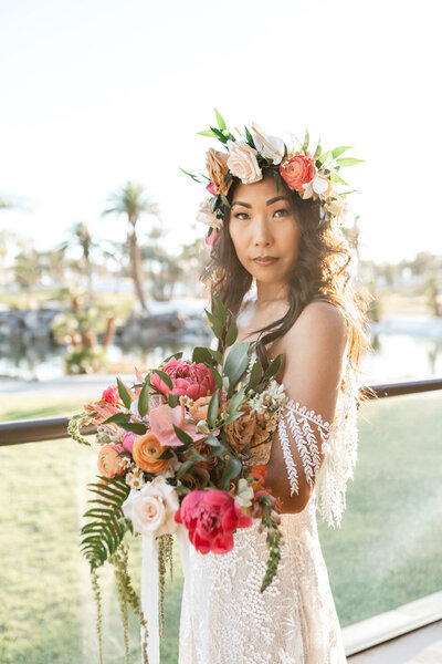Bride with tropical bouquet and flower crown basks in sunset beauty
