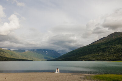 bride and groom walking on a snowy mountain with rolling hills in the background