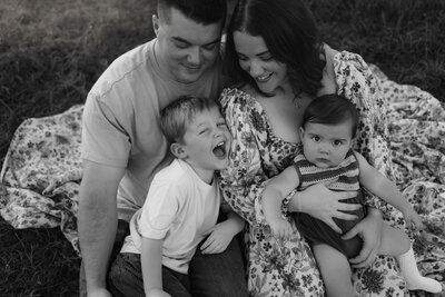 black and white family photo of parent and two little kids