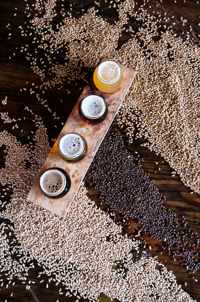 Birds eye view of a four glass beer flight on top of a pile of grain