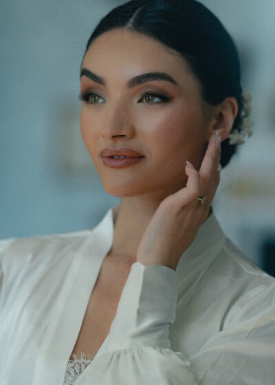 Elegant modern bride striking a pose, showcasing her stunning wedding dress and radiating confidence in a stylish, intimate setting