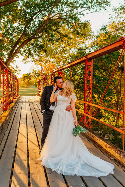 photo of a bride and groom during a Tennessee wedding hugging on a bridge at Golden hour