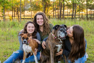 Corry's 3 teenage daughters and 2 dogs smile in field for photo