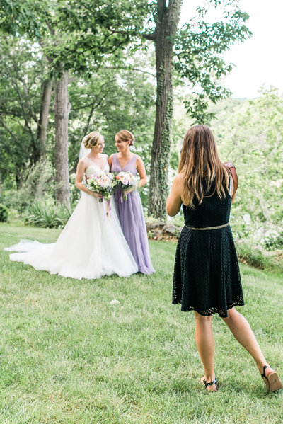 Image of a photographer photographing a bride and her maid of honor.