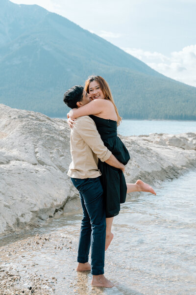 Man picks up wife for romantic couples photo session in Banff National Park.