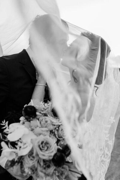A wedding couple under the wedding veil in black and white at Bella Collina by Florida wedding photographer Angelika Krug Photo & Film
