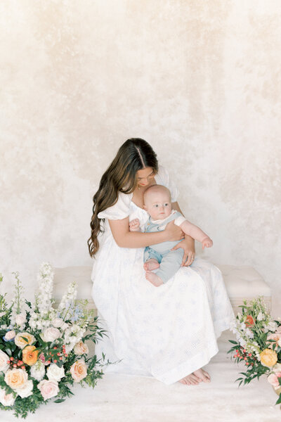Mom holding baby in front of photo gallery for Richmond Newborn Photography session.