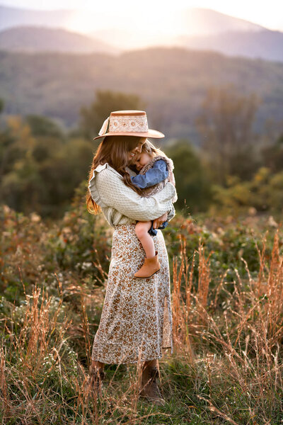 A sweet mom and daughter snuggling in the beautiful mountains in Asheville
