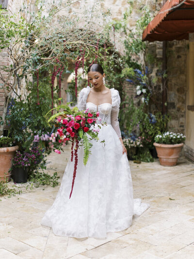 bride in a white dress holding a bright pink bouquet