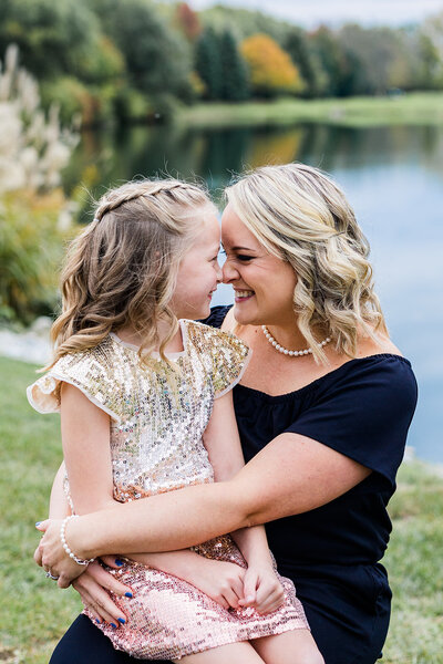 a mom and her daugther touching noses for a family photo shoot