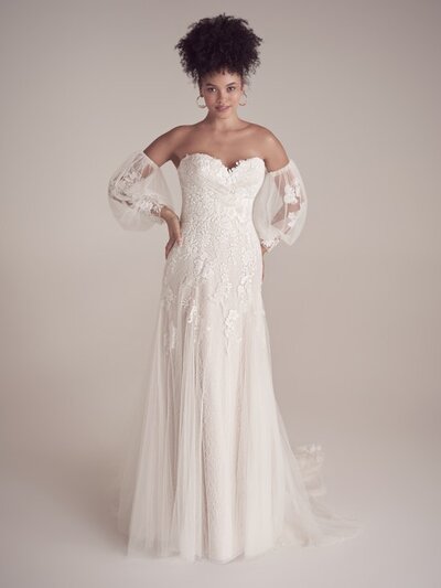 A romantic off-shoulder neckline and beautifully ornate appliques are the focal points of thie ballgown.