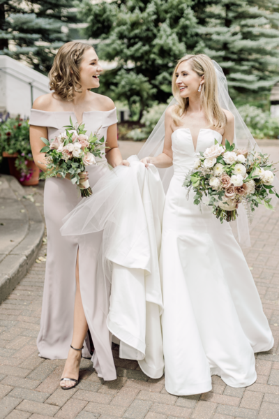 bride and bridesmaid walking with bouquets