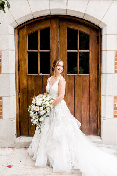 bride smiling in front of door at Glenmoor Country Club