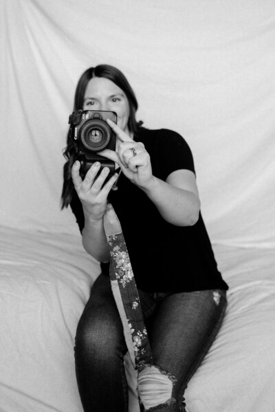 Savannah holding her camera, ready to capture your motherhood journey