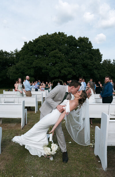 newlyweds dip at the end of the aisle after saying "I do"