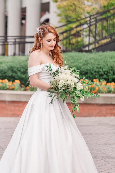 A redheaded bride holding a colorful wedding bouquet at The Prestonwood Country Club enjoying her destination wedding photos by JoLynn Photography