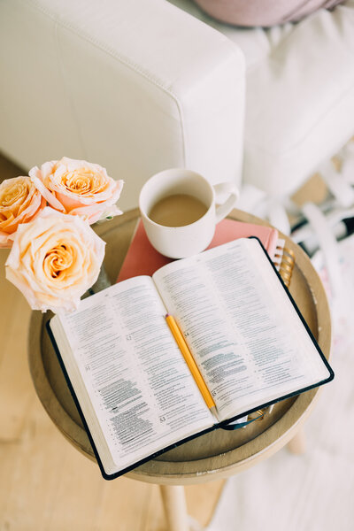 an open Bible and a cup of coffee sitting on  a table