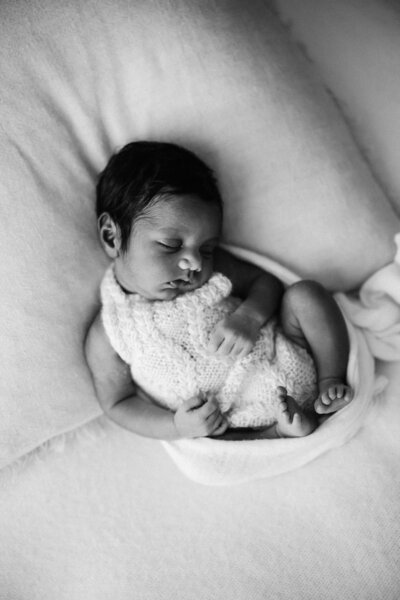 Baby vyshnavi is curled up and asleep, photographed by newborn photographer aimee kelly photography