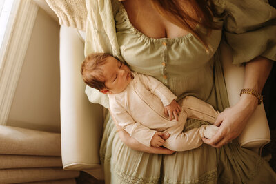 mom holding baby in chair