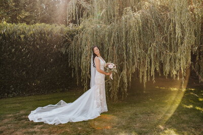 Bride standing under willow tree