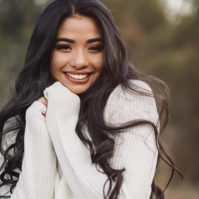 hispanic girl in white sweater at her senior photoshoot