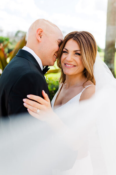 Veil shot portrait of bride and groom at Trump National Golf Club in Jupiter FL