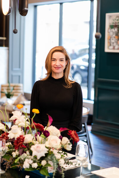 Modern headshot of a florist with a large floral design